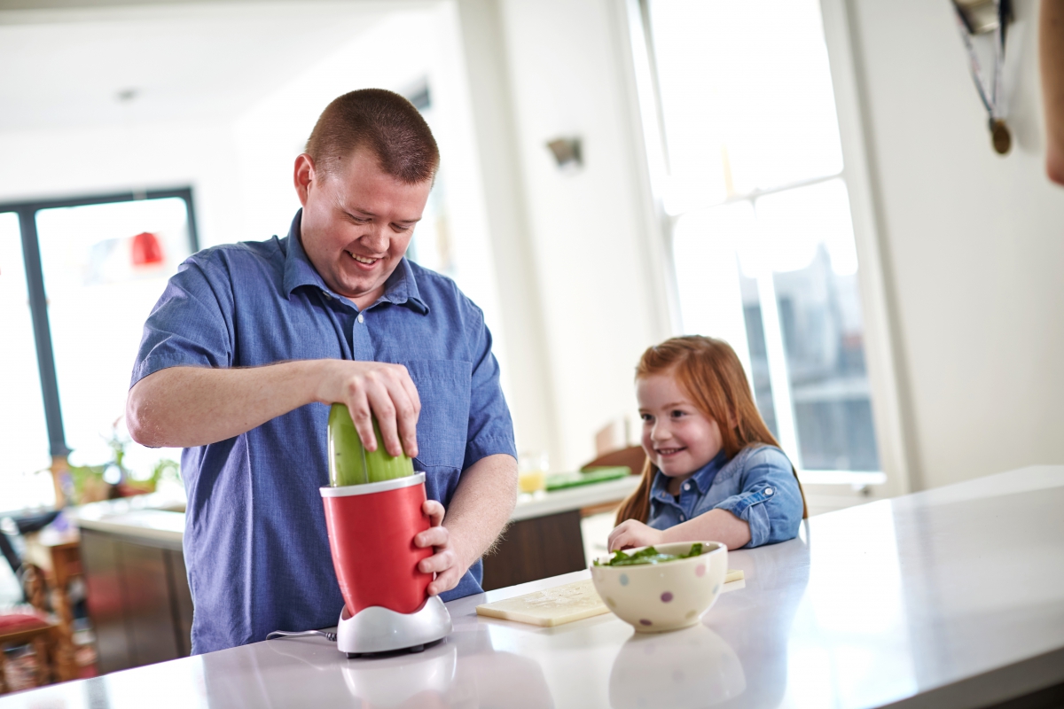 Dad making healthy smoothie for daughter