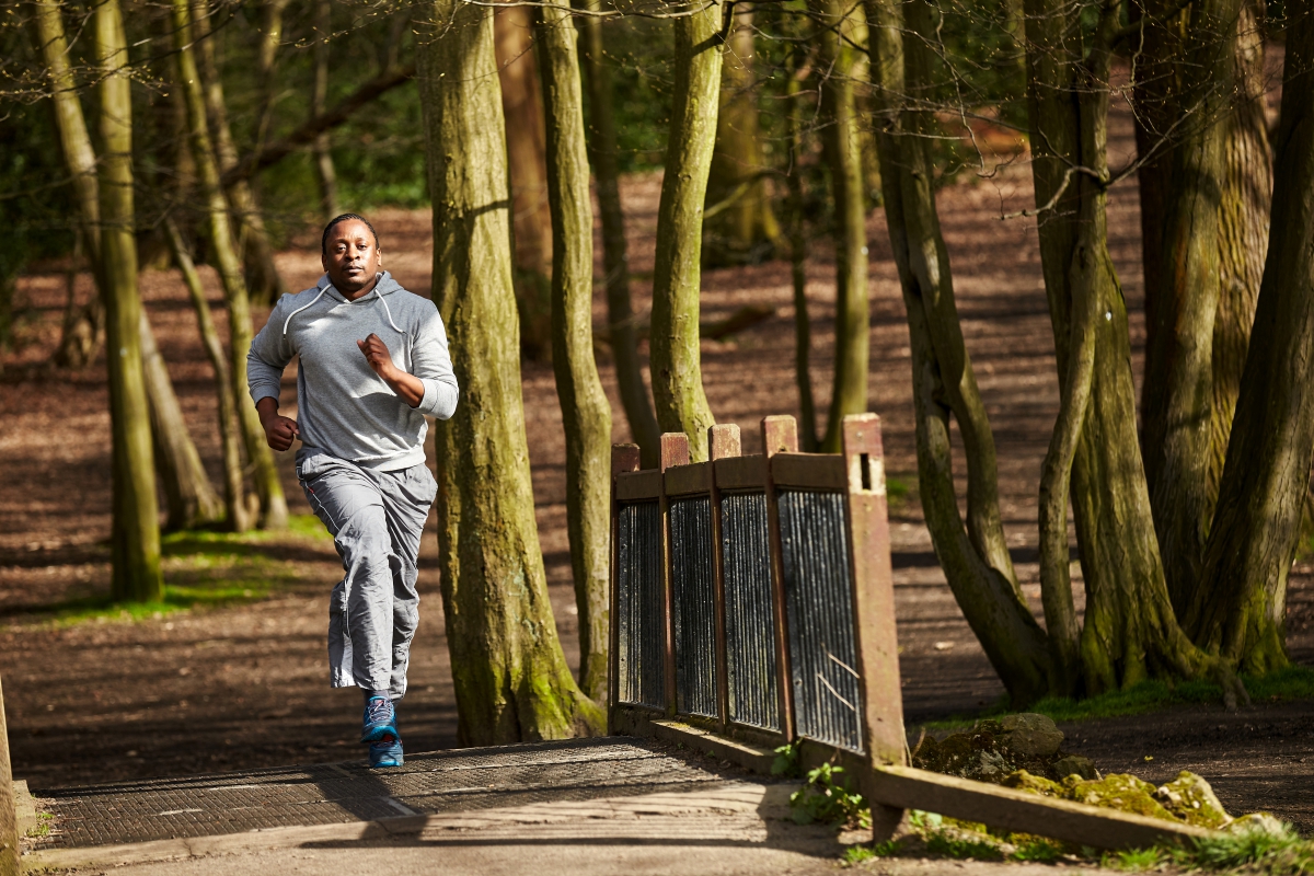 Man running over a bridge in the woods