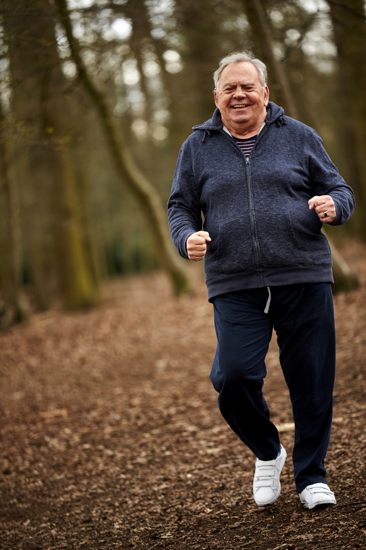 Older gentleman power walking in woods