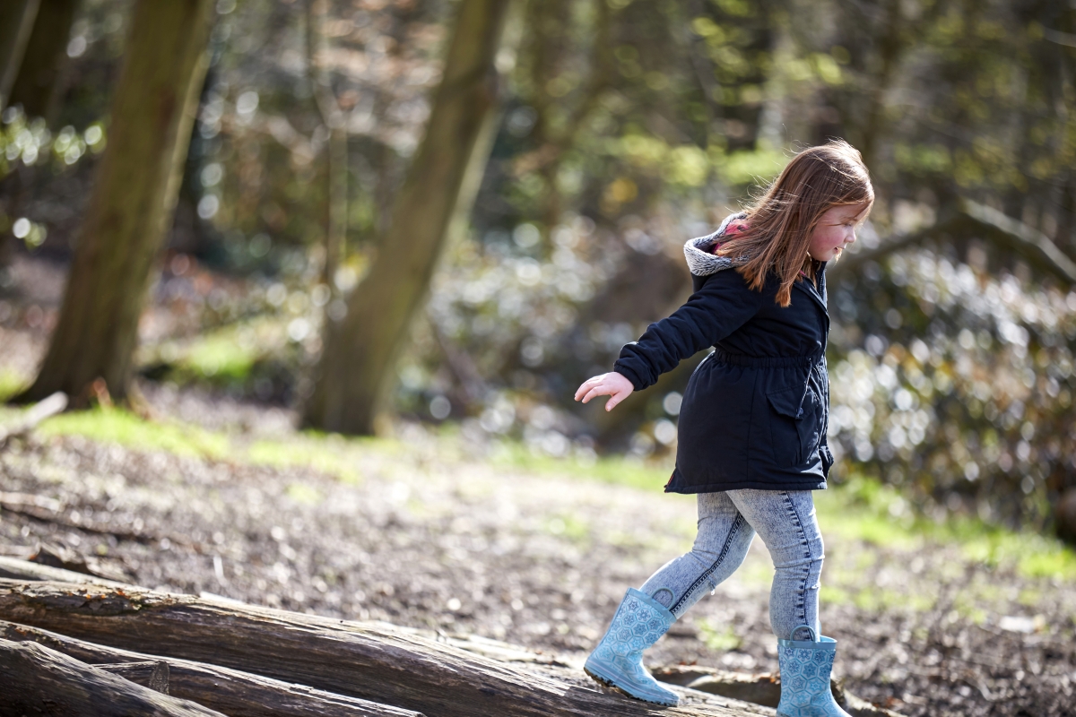 Little girl playing in the woods 