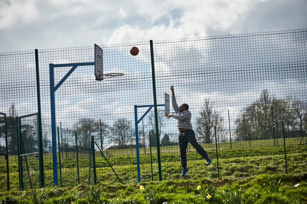 Man shooting hoops on basketball court
