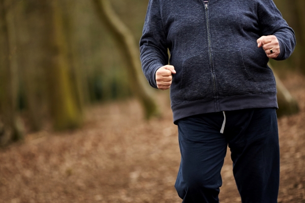 Older gentleman power walking in woods 