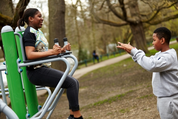 Teenagers on exercise equipment in park