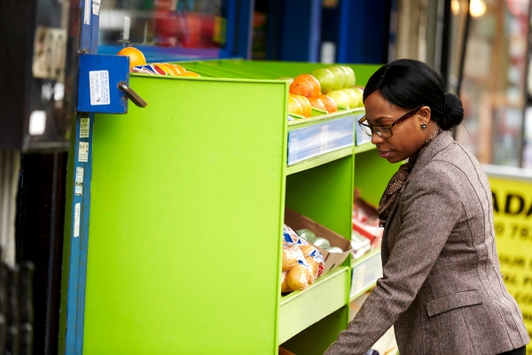 Business woman sees fruit outside shop 