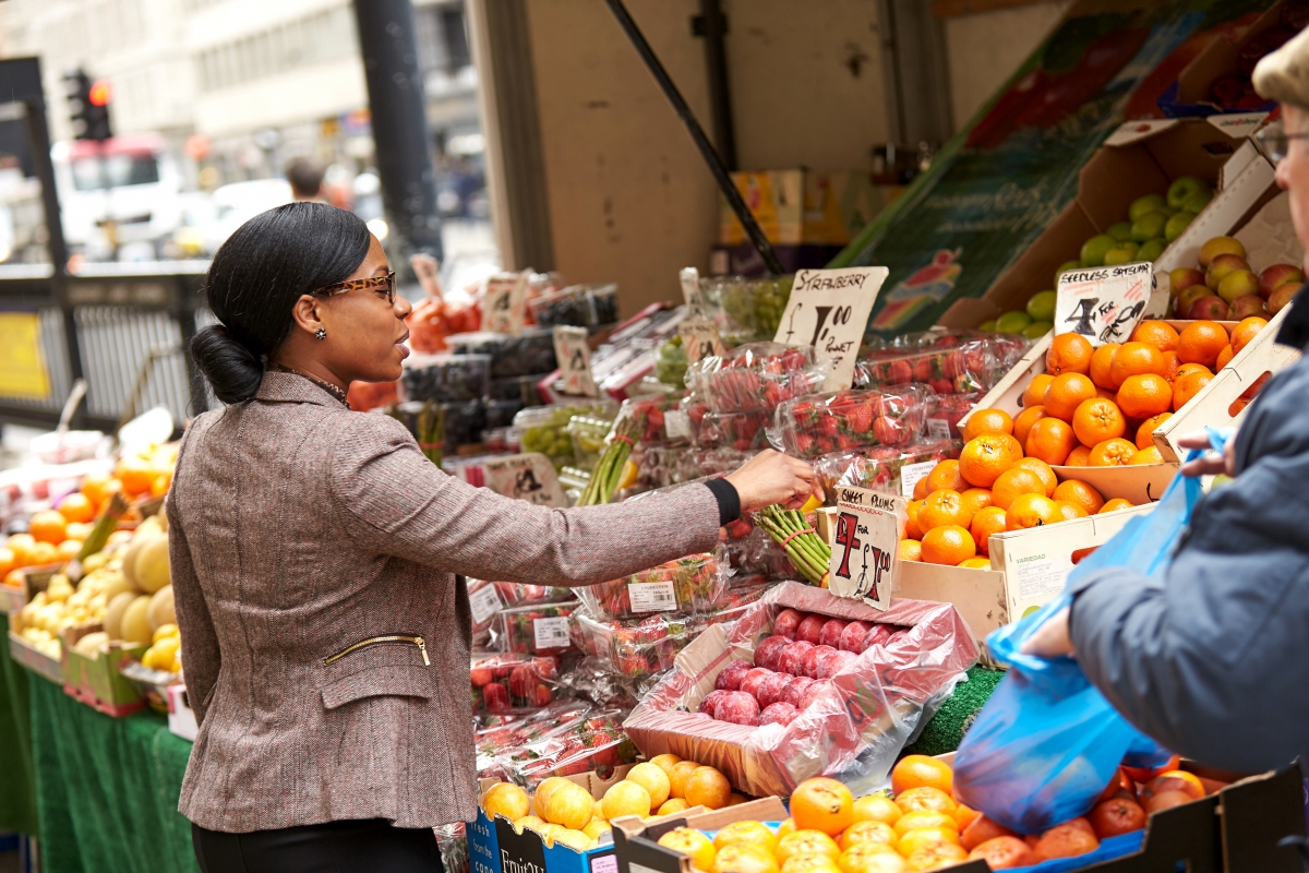 Business woman checking fruit on a stall 