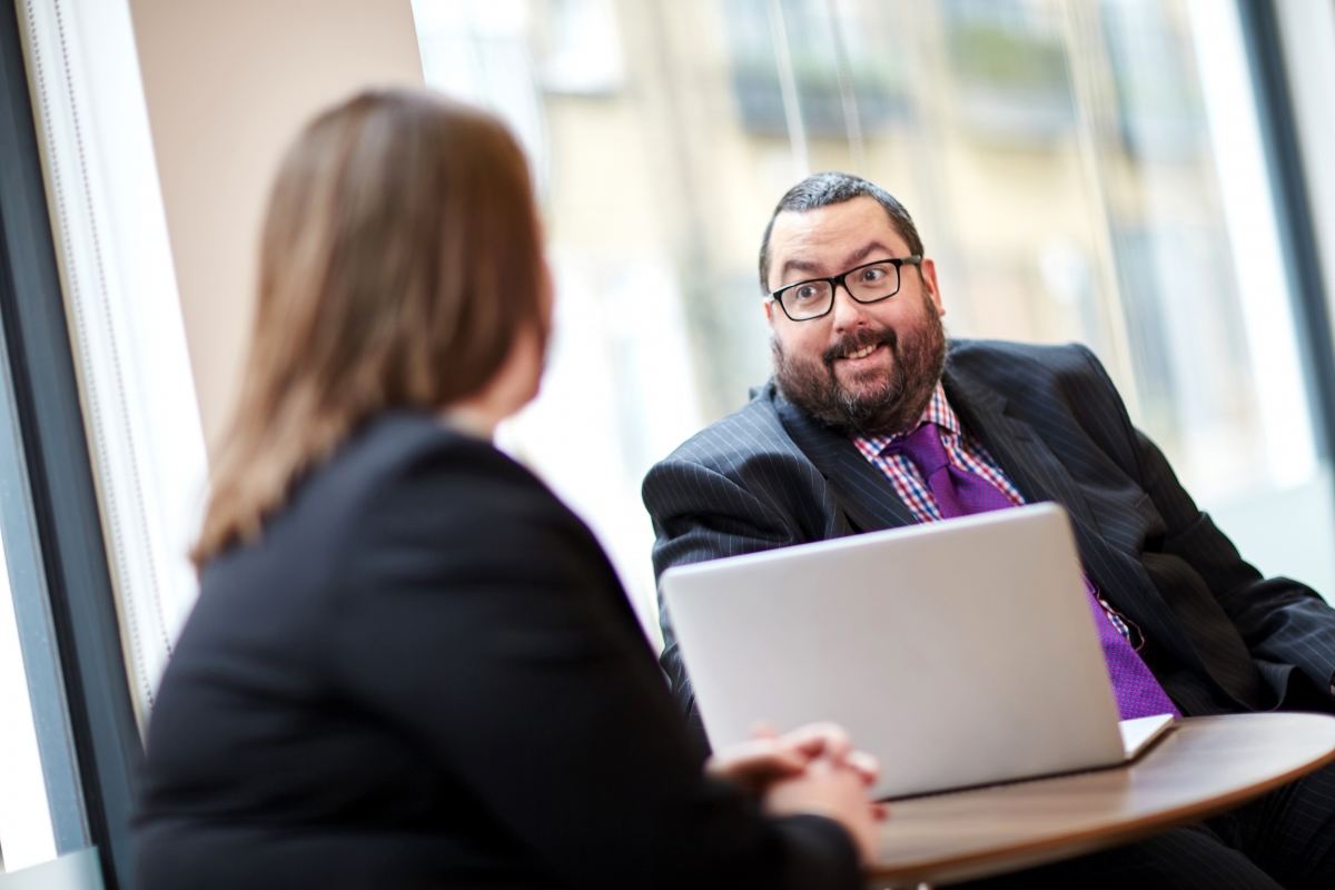 Man and woman at desk with laptop