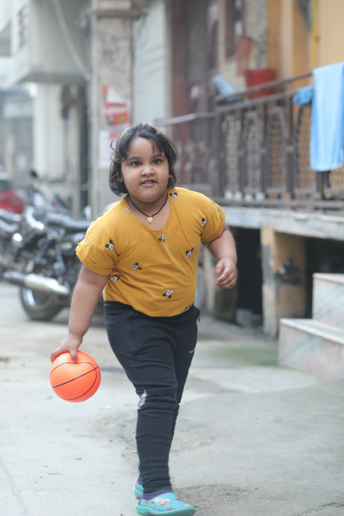 Child playing outside with a ball