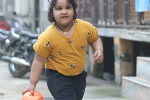Child playing outside with a ball