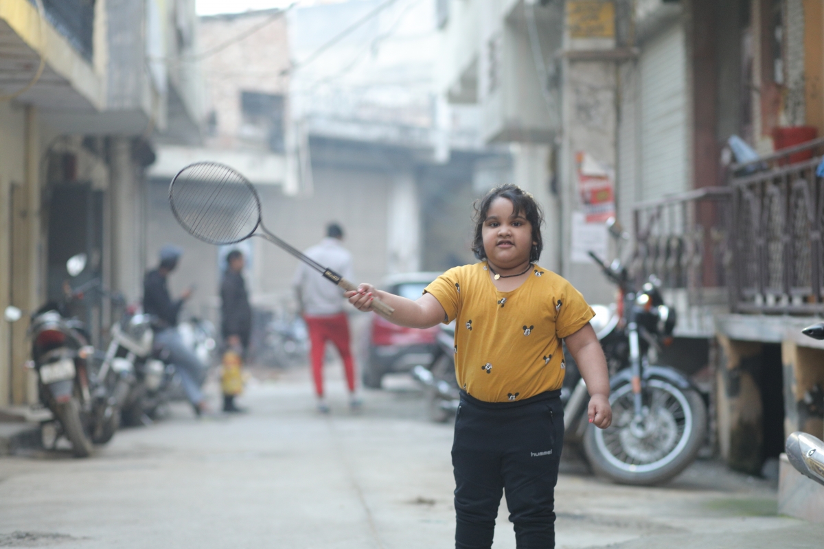 Child with a racquet in the street