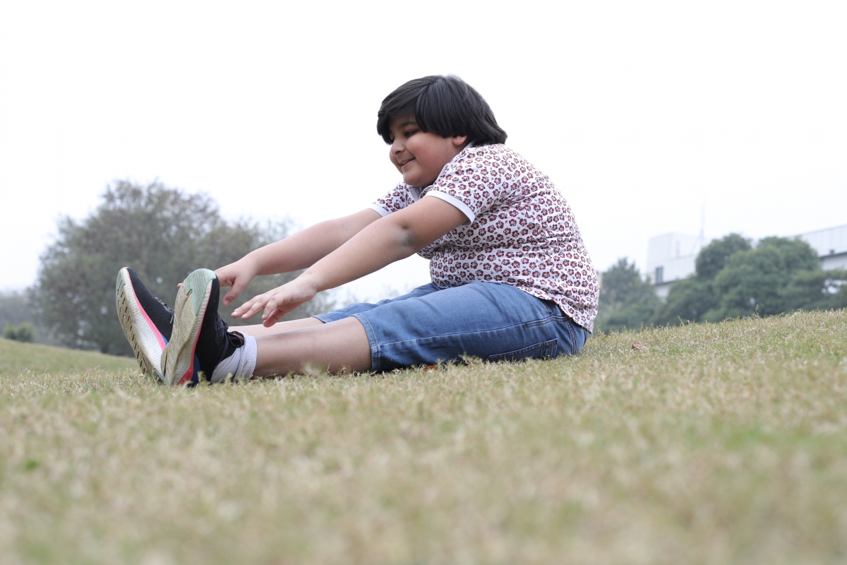 Child stretching in a park