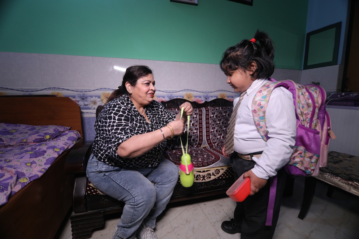 Woman giving water bottle to a child