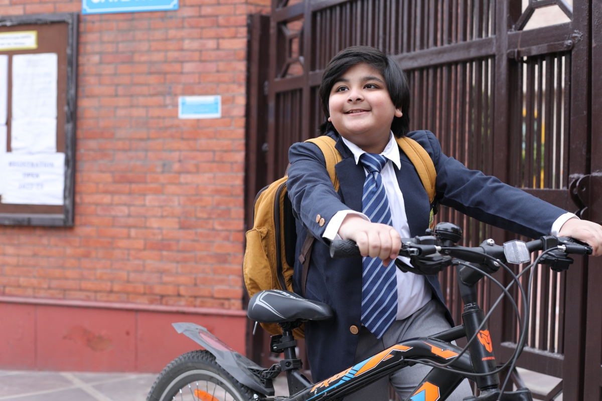 Child with bike outside school