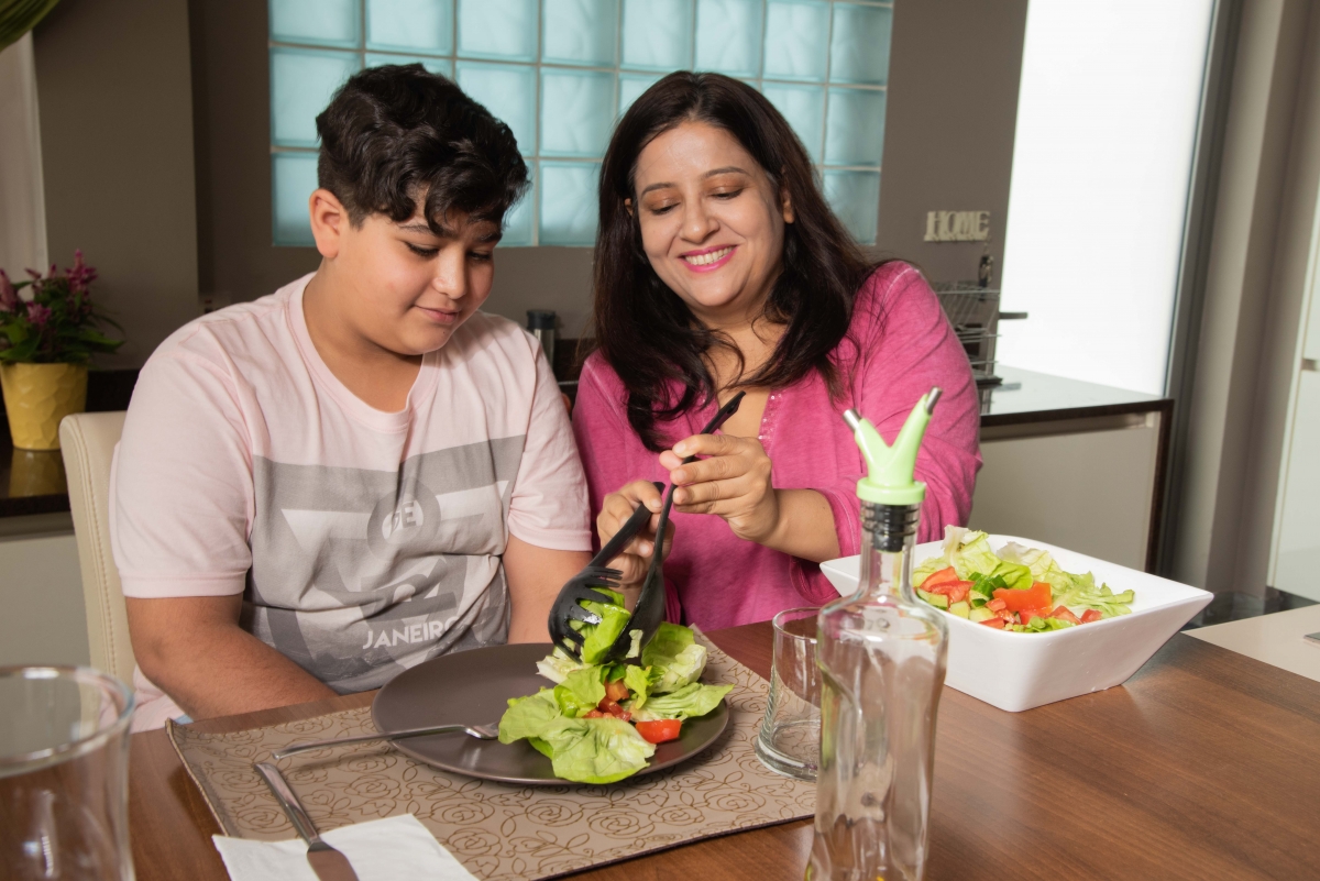 Mother serves son at dinner